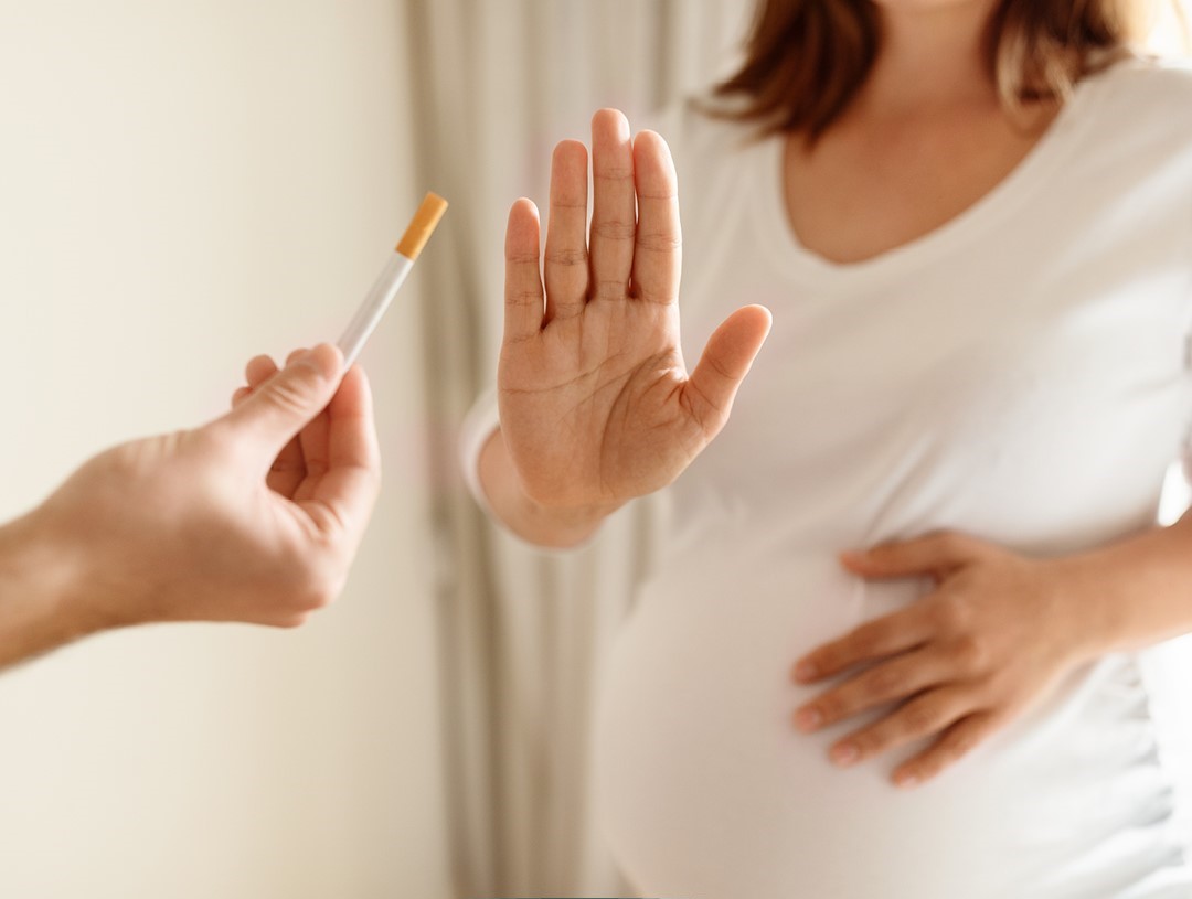 A pregnant woman saying no to being offered a cigarette 